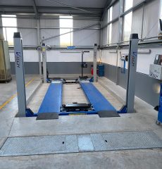 Garage workshop with recessed wheel alignment and vehicle inspection equipment.