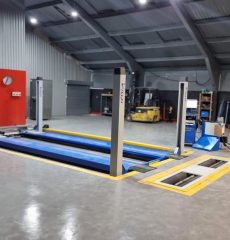 Heavy-duty four-post vehicle lift for commercial vehicle testing and alignment.