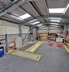 Vehicle testing lane with wheel alignment and inspection equipment.
